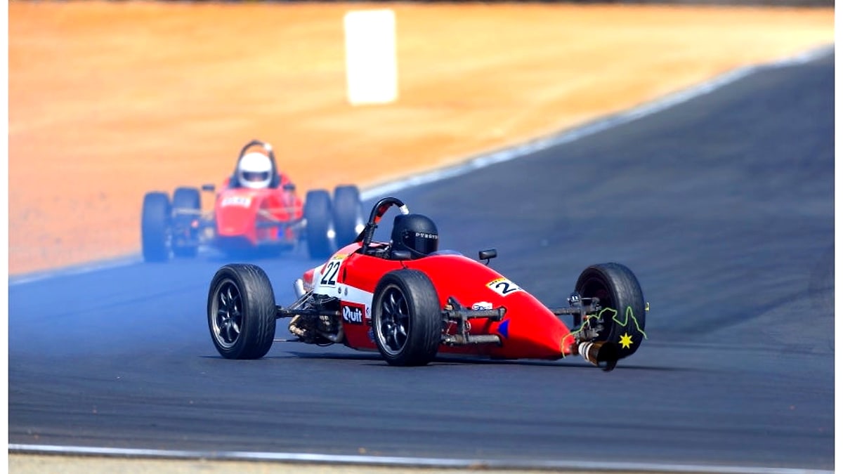 Formula Vee race car on track with smoke behind